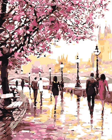 Romanttinen kevätnäkymä, jossa ihmiset kävelevät kirsikankukkien reunustamalla rantakadulla vaaleanpunaisen lehtikatoksen alla.